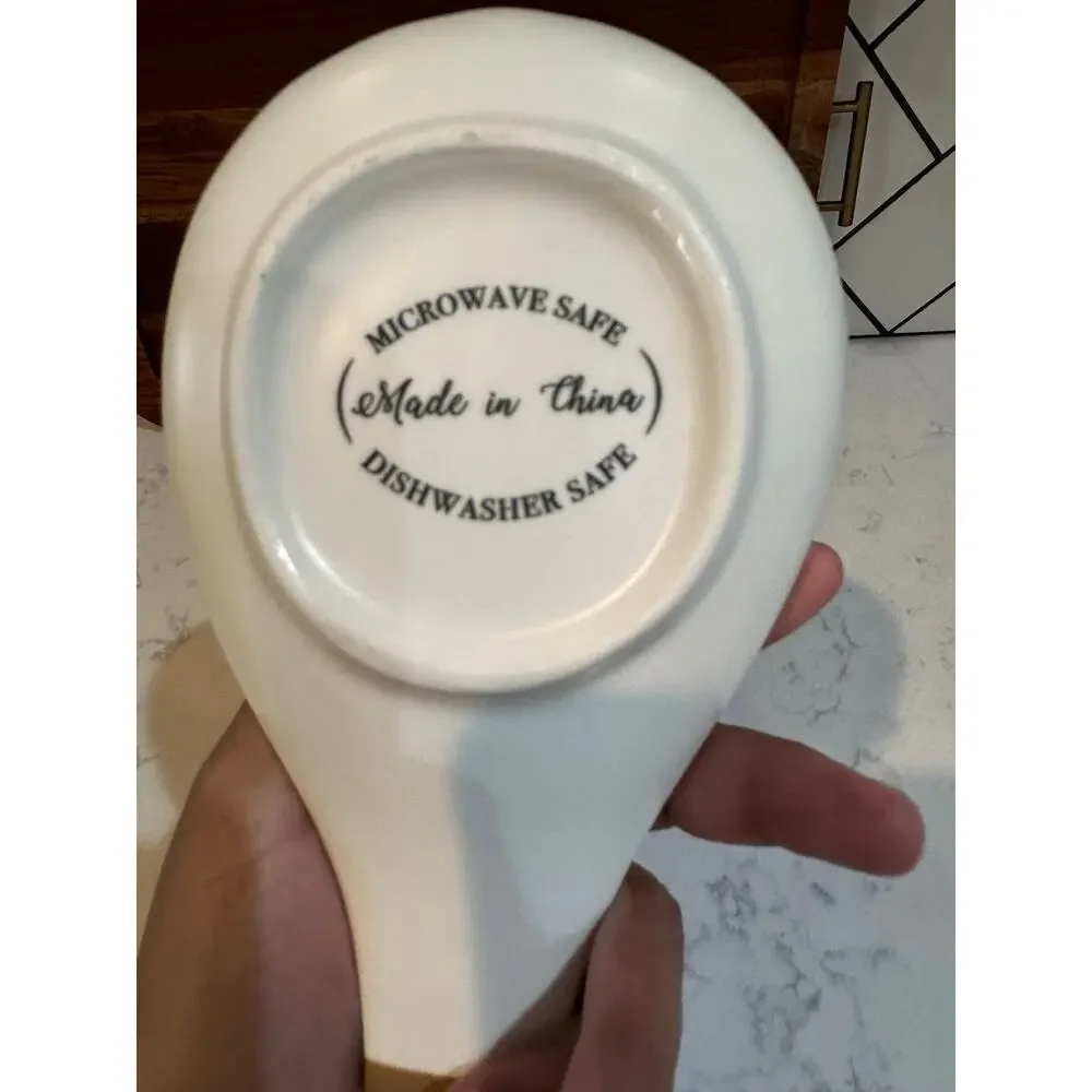 white ceramic spoon rest black bee graphic contrasting brown dipped handle